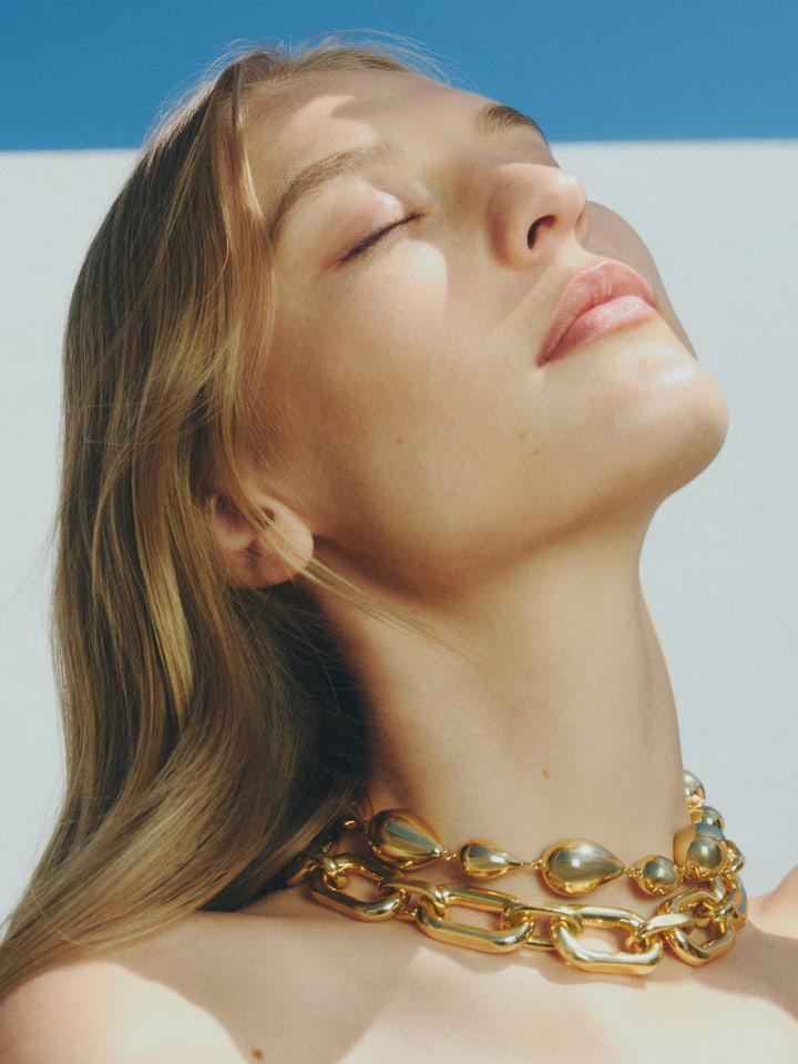 Woman in gold zahra necklace and gold elliot crystal necklace