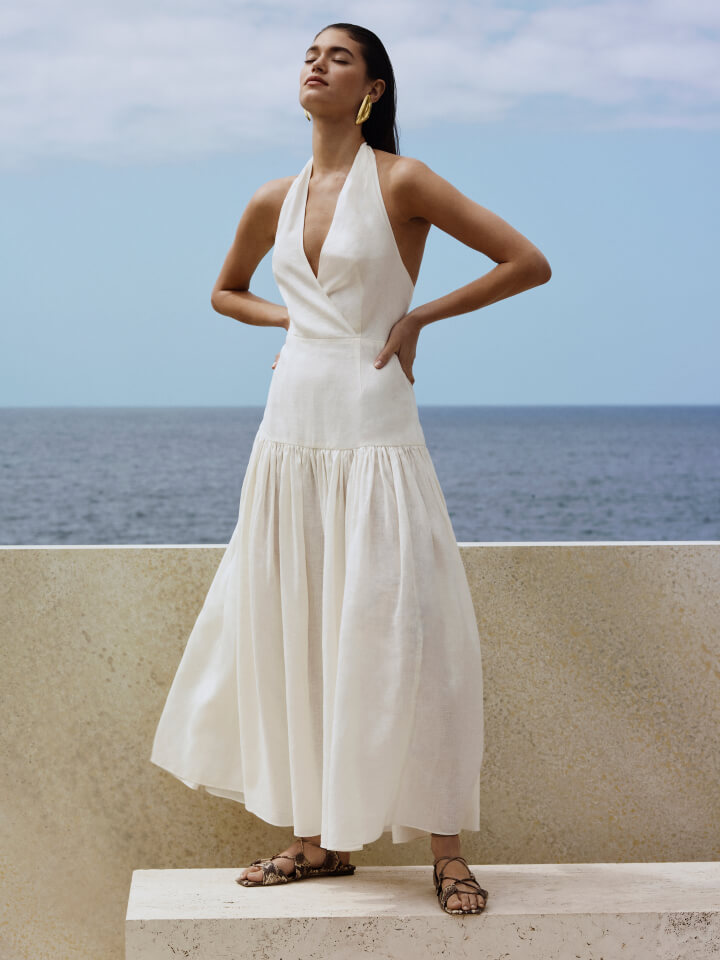Woman in white utility pocket shirt and white linen bubble skirt