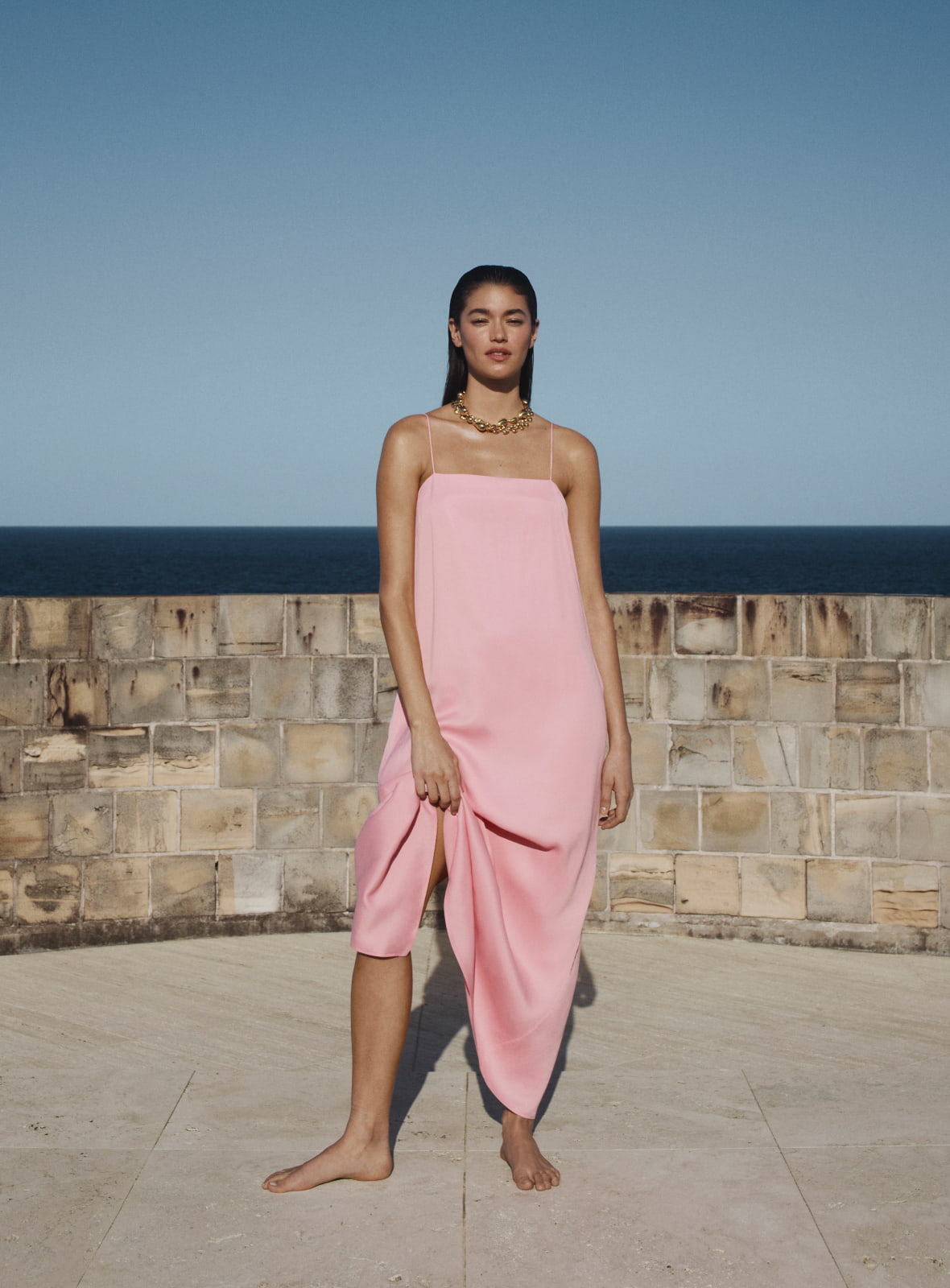 Woman in white wide neck mini dress and blakc grace mule