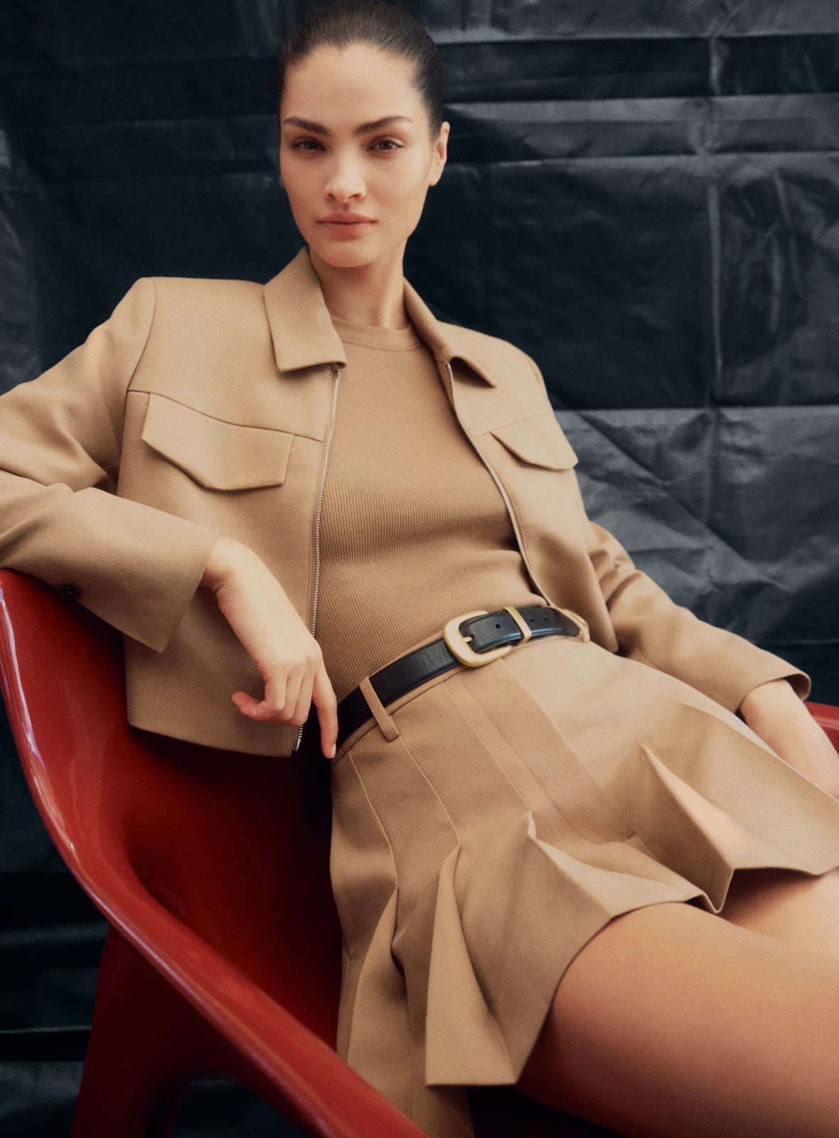 Woman in brown high neck gather top and brown pleat fluid pant