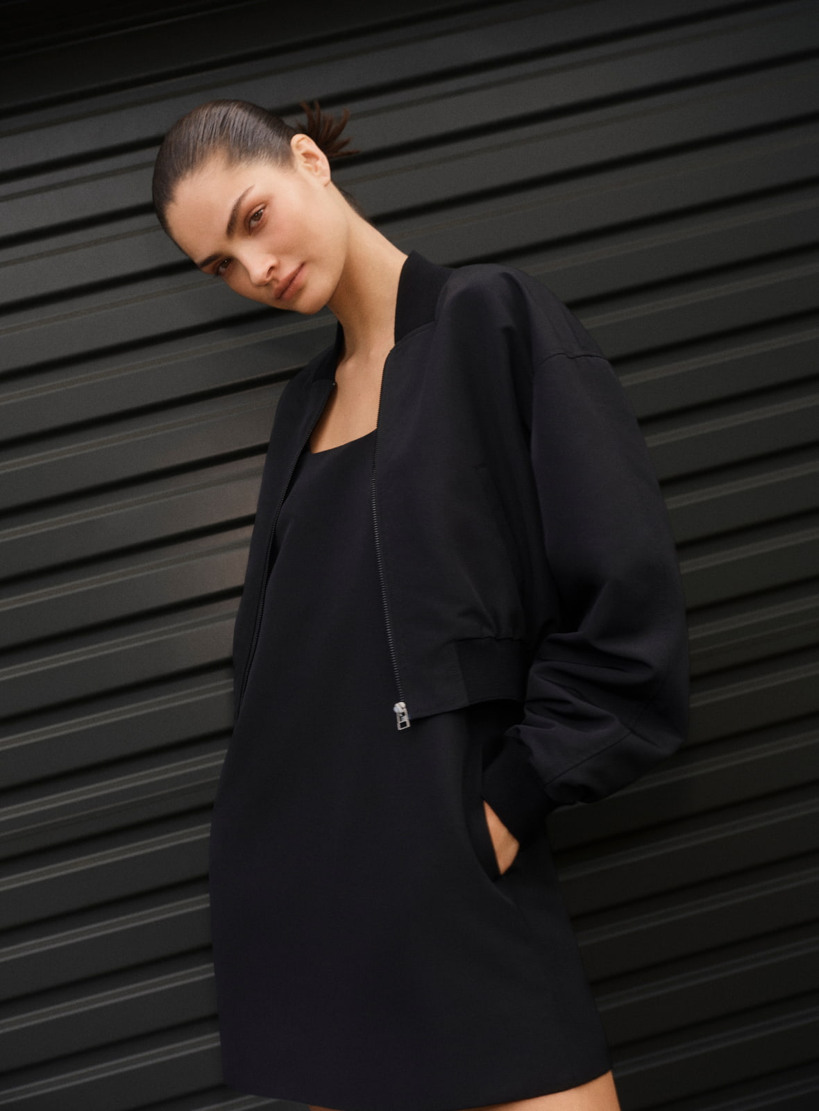 Woman in white wide neck mini dress and blakc grace mule